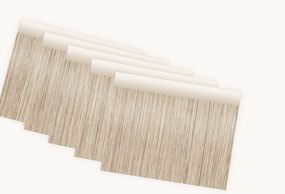 A stack of tape-in hair extension wefts showing the flat tape bond along the top edge